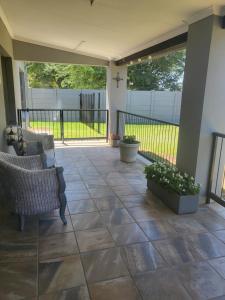 une terrasse couverte avec des chaises et des plantes. dans l'établissement Tranquility, à Bloemfontein