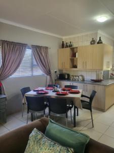 a living room and kitchen with a table and chairs at Tranquility in Bloemfontein