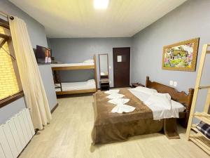 カネラにあるPousada Bella Serraのベッドルーム1室(ベッド1台、二段ベッド1組付)