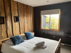 Una cama o camas en una habitación de Hostal Plaza Chiloe