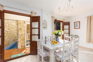 a dining room with a table with a vase of fruit at Villa Flower in Cómpeta