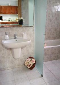 een badkamer met een wastafel en een ligbad bij CASA DA VOVÓ CÉU - Casa de Campo Gandaresa - Country House, entre COIMBRA e AVEIRO, a 15 minutos carro Praia Mira - Quintal com piscina insuflável in Cantanhede +23 foto's