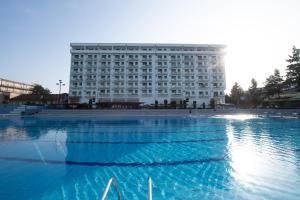a large building in front of a large swimming pool at Petković apartmani 87 in Jagodina