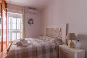 1 dormitorio con 1 cama con toallas en Apartamento Playa La Caleta, en Cádiz