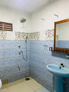 ein Bad mit einem Waschbecken und einer Dusche mit einem Spiegel in der Unterkunft The River Villa in Talpe