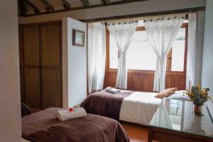 1 Schlafzimmer mit 2 Betten und einem Fenster in der Unterkunft VILLA CHARLOTTE 1 en colombia in Villa de Leyva
