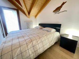 ein Schlafzimmer mit einem großen Bett und einem Fenster in der Unterkunft Trilo Riflessi d'Alpe in Lavarone