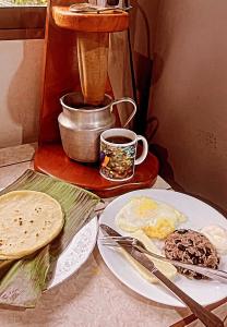 una mesa con platos de comida y una cafetera en Cacahua Paradise Lodge, Río Celeste, en Rio Celeste