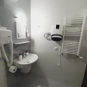 a white bathroom with a toilet and a sink at VIP Apartments Belvedere with terrace K105 in Bansko