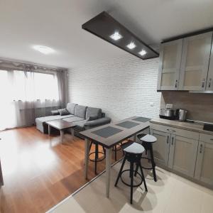 a kitchen and living room with a couch and a table at VIP Apartments Belvedere with terrace K105 in Bansko
