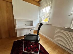 uma cadeira preta sentada num quarto com uma janela em Historische Unterkunft 2 in Lorch em Lorch