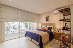 Un dormitorio con una cama y una ventana grande. en Estúdio Estiloso no Pátio Milano, en Florianópolis 40 fotos más
