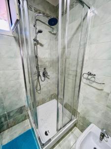 a shower with a glass door next to a sink at Cocò Marì in Naples