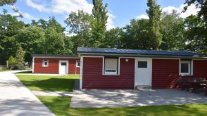 a red building with a picnic table in a park at Feriendorf am Flämingbad in Coswig