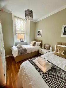 a bedroom with two beds and a chandelier at Sea Breeze in Anstruther