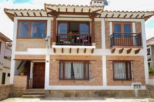 ein Backsteinhaus mit Fenstern und einem Balkon in der Unterkunft Villa charlotte 3 en colombia in Villa de Leyva