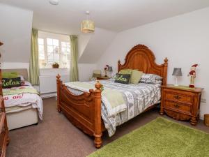 ブリドリントンにあるThe Mewsのベッドルーム1室(大きな木製ベッド1台、緑のラグ付)