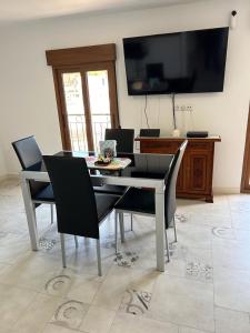 Un comedor con mesa y sillas y un televisor. en Geomar Penthouse, en Alicante
