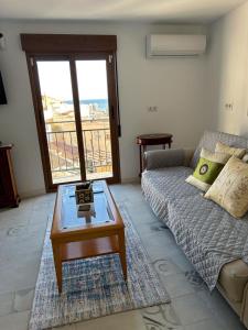 Una sala de estar con un sofá y una mesa de café. en Geomar Penthouse, en Alicante