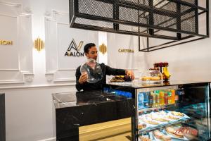 a man standing behind a counter in a store at Avalon Boutique in Valletta