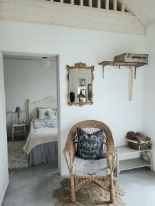 a room with a chair and a bed with a mirror at Mysigt hus i liten by nära havet in Ystad