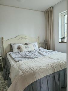 1 dormitorio con 1 cama grande y paredes blancas en Mysigt hus i liten by nära havet en Ystad