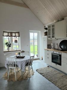 eine Küche mit einem Tisch und Stühlen im Zimmer in der Unterkunft Mysigt hus i liten by nära havet in Ystad