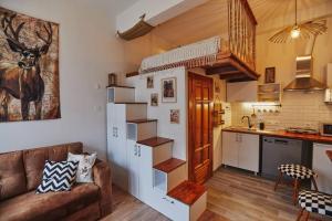 ein Wohnzimmer mit einem Sofa und einer Küche in der Unterkunft Unique hunter's hut concept tiny house 