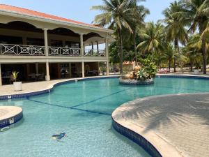 a large swimming pool in front of a hotel at Honduras Shores Plantations in Tela