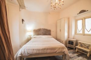 a bedroom with a bed in a room with a chandelier at Lake House in Sassocorvaro