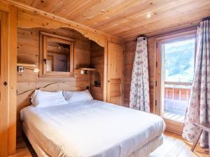 ein Bett in einem Holzzimmer mit Fenster in der Unterkunft Chalet haut standing 14p à 500m des pistes avec parking - FR-1-754-8 in Morzine