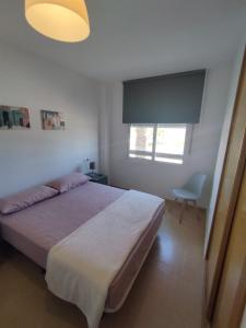 Un dormitorio con una cama grande y una ventana en Las Terrazas de la Torre Golf Murcia, en Murcia