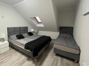 a bedroom with a bed and a nightstand and a bed sidx sidx sidx sidx at Apartamenty Na wzgórzu in Ińsko