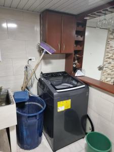 une cuisine avec une cuisinière et une poubelle dans l'établissement Lindo apartamento totalmente Amoblado, à Bogotá