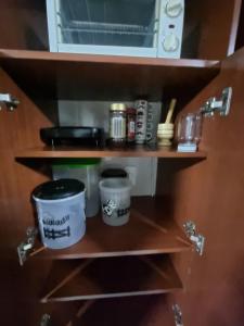 a shelf with pots and pans and a microwave at Lindo apartamento totalmente Amoblado in Bogotá