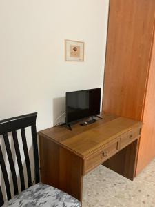 a wooden desk with a television on top of it at Cleo Azalea in Ancona