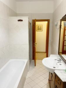 a white bathroom with a tub and a sink at Cleo Azalea in Ancona