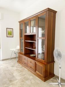 a large wooden cabinet in a room with a fan at Cleo Azalea in Ancona