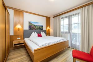 ein Hotelzimmer mit einem Bett und einem großen Fenster in der Unterkunft Pension Kreuzer in Flachau