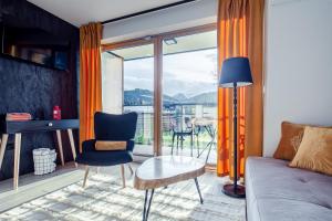 een woonkamer met een bank en een tafel bij Tatra Open Air Księżycowe Apartamenty SPA in Zakopane