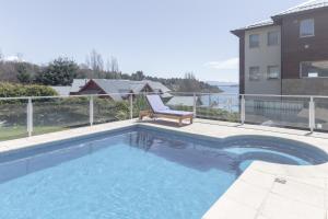 a swimming pool with a chair next to a building at Great 2-Bedroom Apartment close Playa Bonita QL5 by Apartments Bariloche in San Carlos de Bariloche