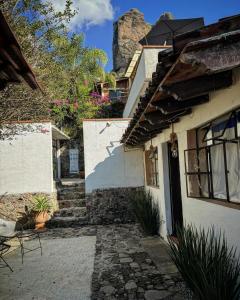 una casa con una pasarela de piedra junto a un edificio en Hospedaje Casa Teotleco en Tepoztlán