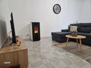sala de estar con sofá azul y chimenea en Casa Almeida - Castelo Branco en Castelo Branco