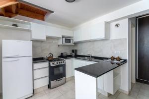 a kitchen with white appliances and a black counter top at Great 2-Bedroom Apartment close Playa Bonita QL5 by Apartments Bariloche in San Carlos de Bariloche