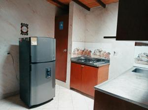 een keuken met een koelkast en een fornuis bij Habitacion cama doble en sabaneta in Sabaneta