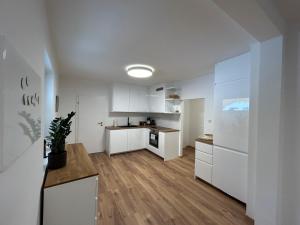 a kitchen with white cabinets and a wooden floor at Ferienwohnung Gmunden City in Gmunden