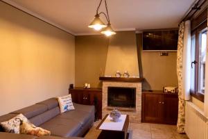 sala de estar con sofá y chimenea en Apartamentos Ohana, en Jadraque