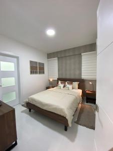 a bedroom with a large bed with white walls at JRVII in Santo Domingo