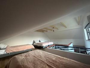 een zolderkamer met 3 bedden en een raam bij Jaga Family Apartment air conditioner and free parking in Krakau