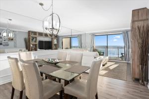 a dining room and living room with a table and chairs at Oceanfront 2 Bedroom Modern Beach Condo w Pool in Ocean City